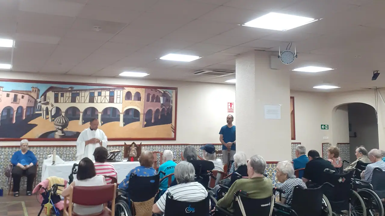 Salón de Mejora Navalmoral, con el mural de la pared, durante una celebración con los residentes
