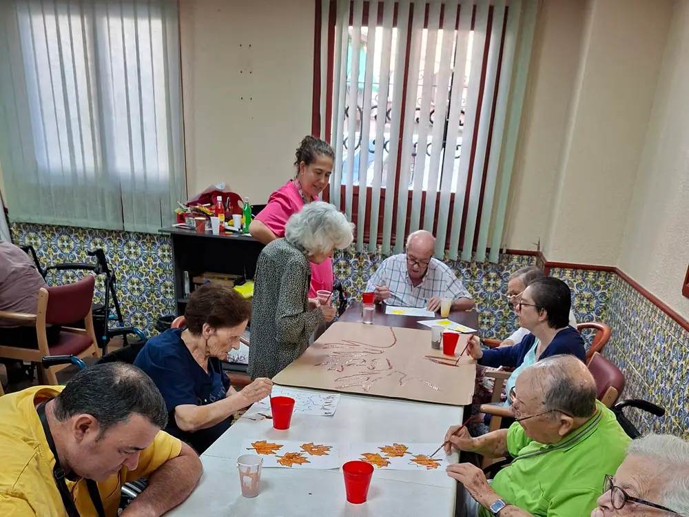 Residentes en una actividad de mesa en la sala de actividades