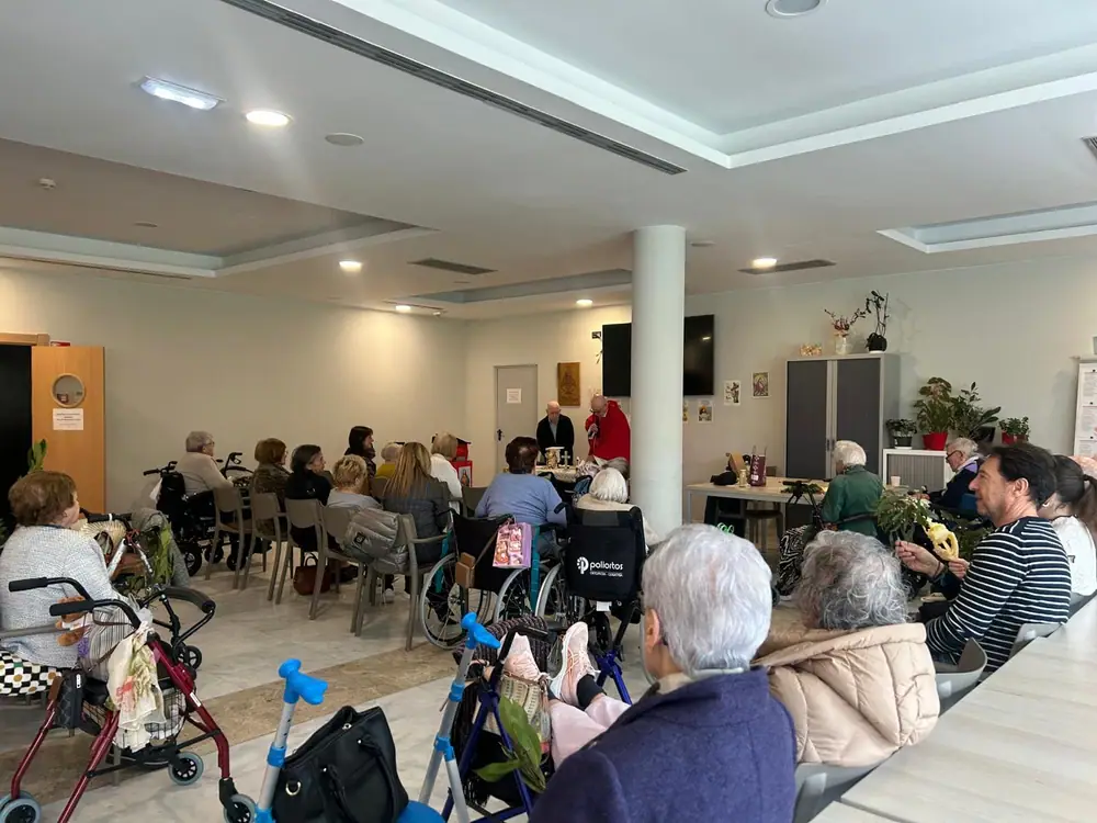 Residentes y familiares reunidos en el comedor durante una celebración
