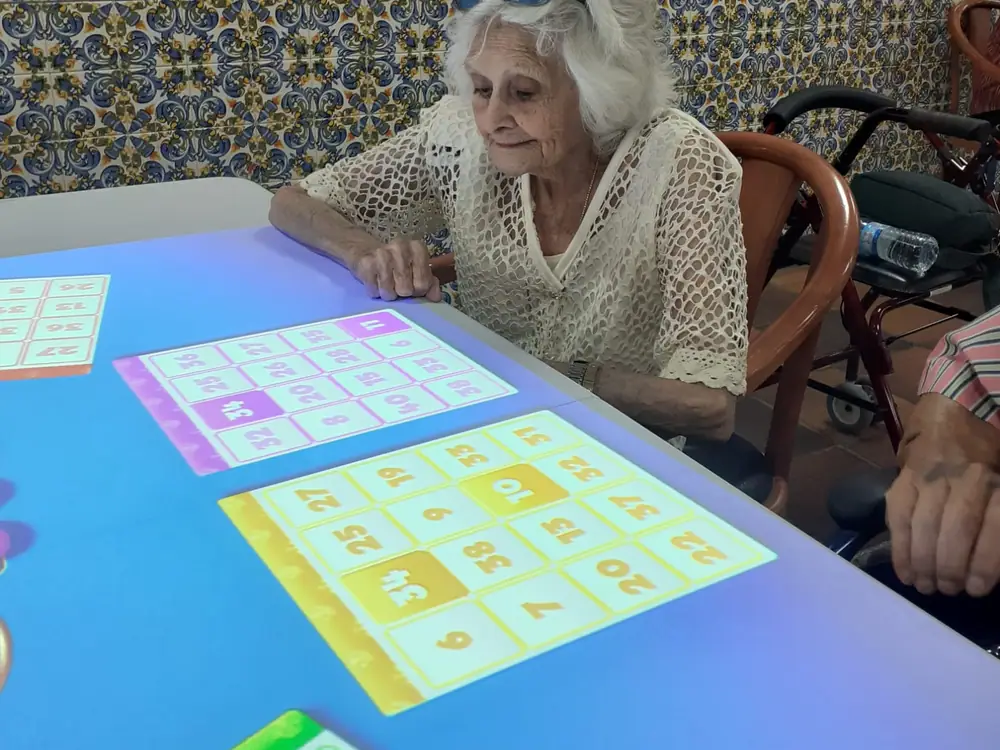 Una residente juega en la mesa interactiva con números proyectados