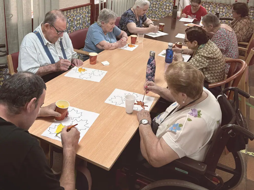 Residentes alrededor de una mesa durante una actividad de pintura