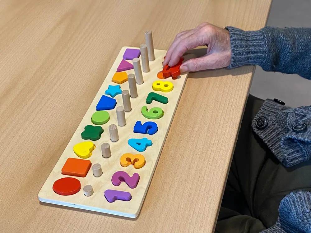 Juego de encaje con números y formas durante una sesión de estimulación cognitiva