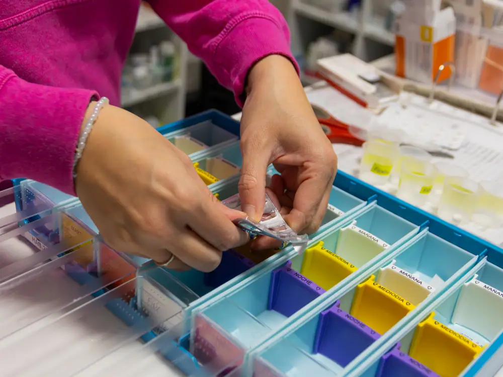 Una profesional prepara la medicación en los pastilleros semanales