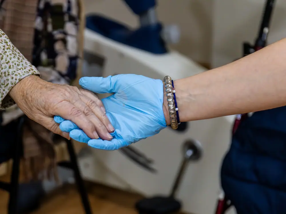 Una profesional sostiene la mano de un residente