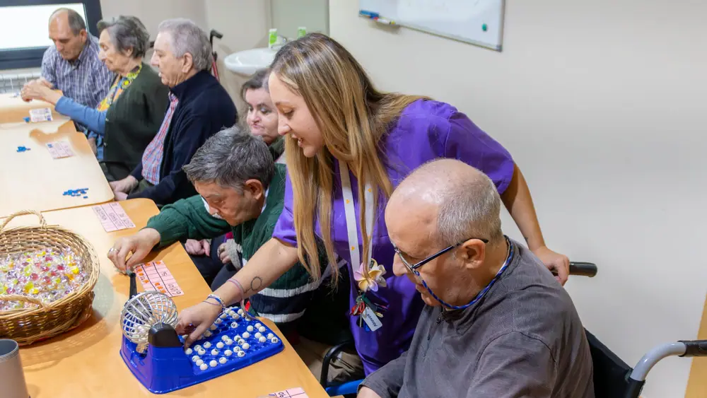 Partida de bingo con residentes y una profesional del equipo en Mejora Benavente