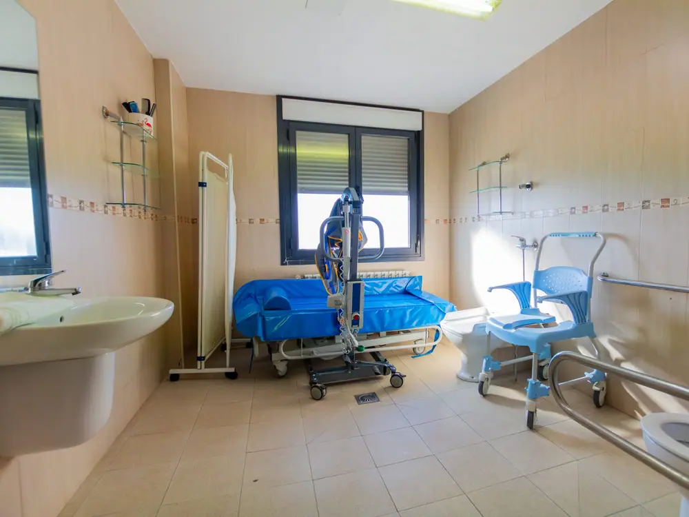 Baño geriátrico adaptado con grúa y bañera asistida