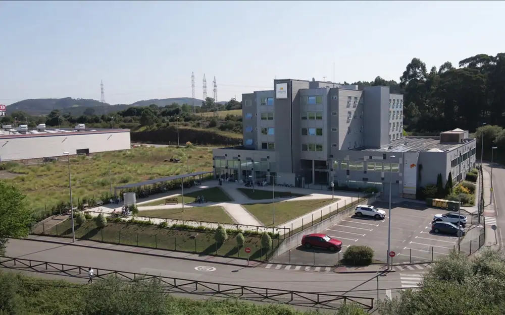 Vista aérea de Mejora Avilés: el edificio, su aparcamiento y las zonas verdes que lo rodean en Trasona