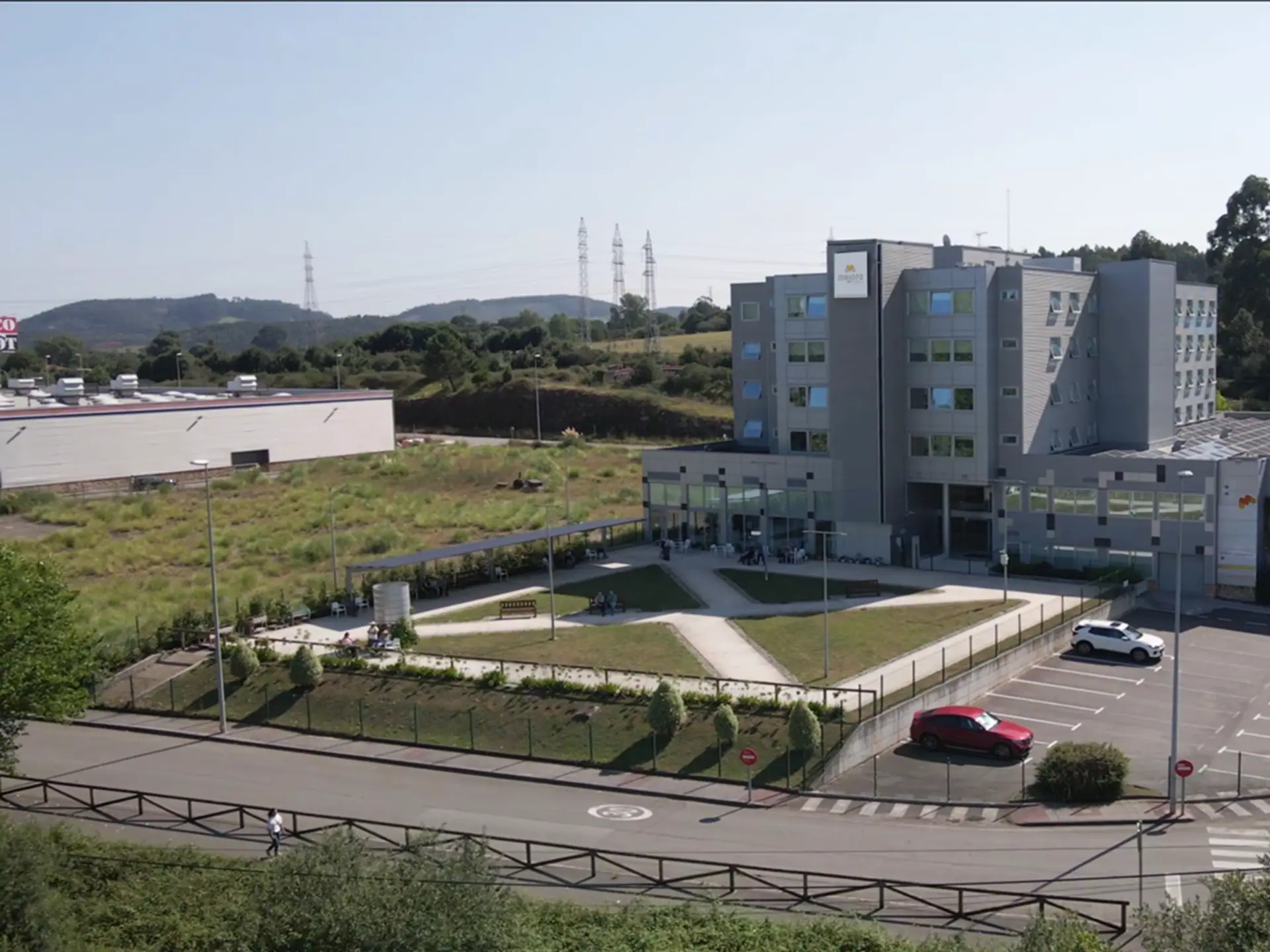 Vista aérea de Mejora Avilés: el edificio, su aparcamiento y las zonas verdes que lo rodean en Trasona